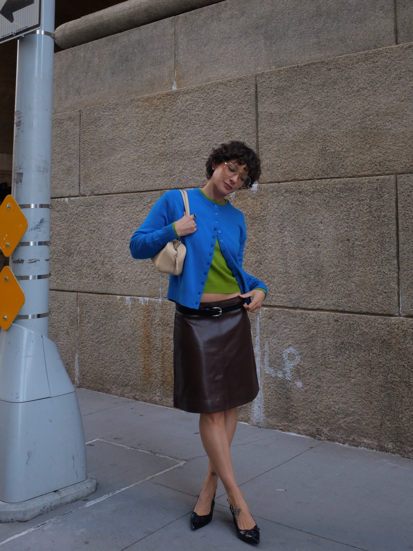 Woman in blue cardigan and brown leather skirt