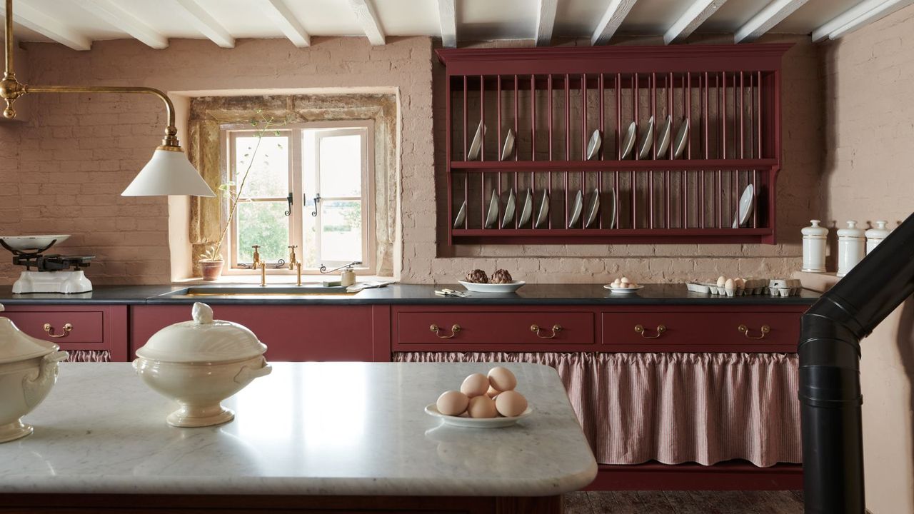 Cottage kitchen with beamed ceiling, burgundy cabinets and wall mounted dish rack