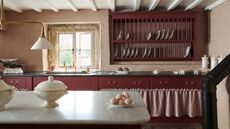 Cottage kitchen with beamed ceiling, burgundy cabinets and wall mounted dish rack