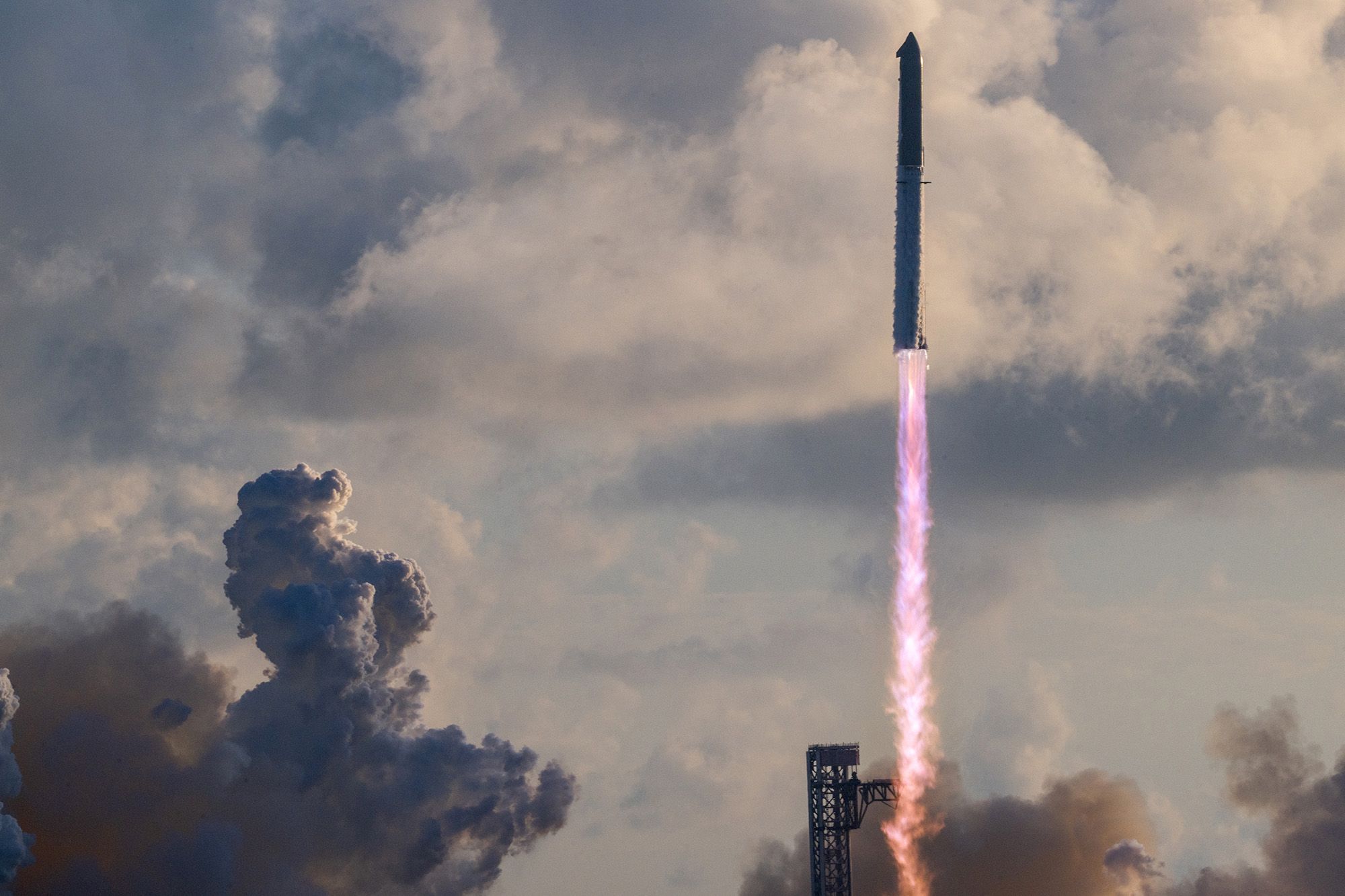 A rocket with purple flame blasts off of a launch pad