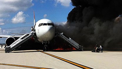 Passengers evacuate from a plane on fire at Fort Lauderdale airport,