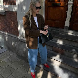 Linda Tol wearing red ballet flats with jeans.