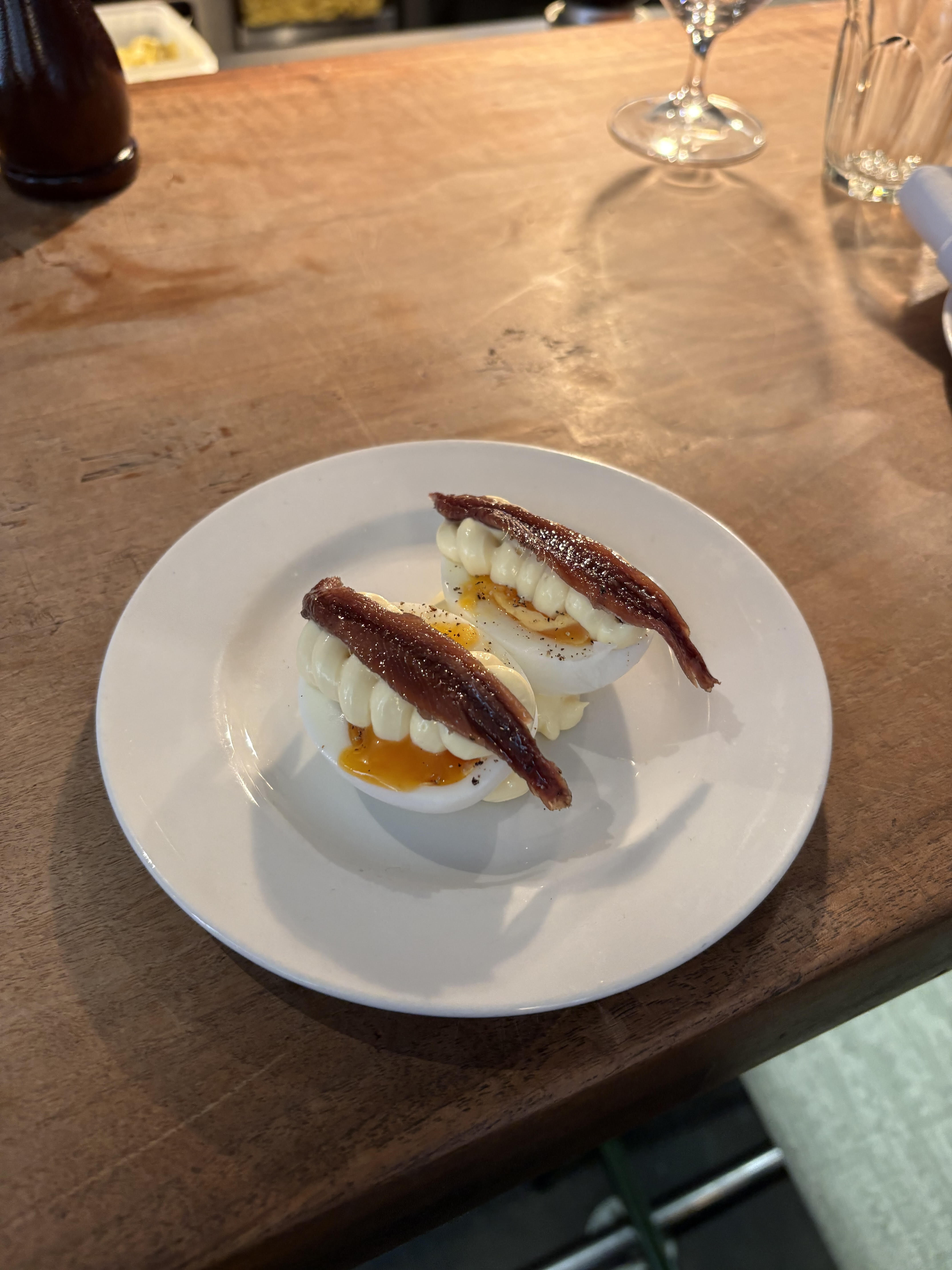 Jammy eggs topped with mayonnaise and anchovy