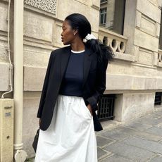 @nlmarilyn wearing a navy sweater with a blazer and a white poplin skirt.