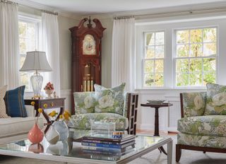cape cod living room with grandfather clock and armchairs with green floral covers