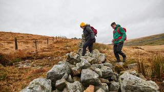 Hikers crossing over a stile