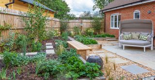 small corner garden with raised planting to demostrate a key small garden tip to maximize planting