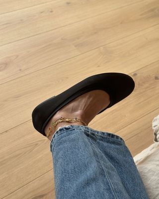 Chocolate brown ballet pump with anklets and straight-leg denim jeans.