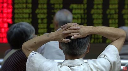 A man in China watches the stock market fall on Monday
