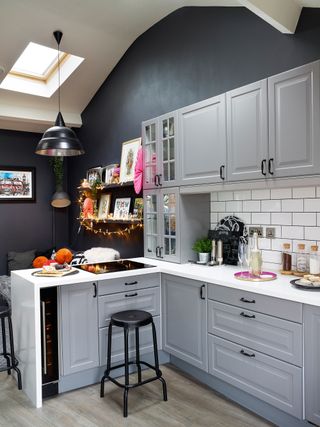 Open-plan kitchen-living space with dark grey walls and grey kitchen cabinets