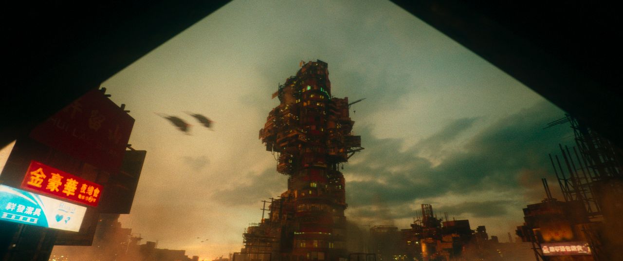 Babiru DaVinci Resolve tips; A large, complex, and imposing structure dominates the urban landscape under a cloudy sky.