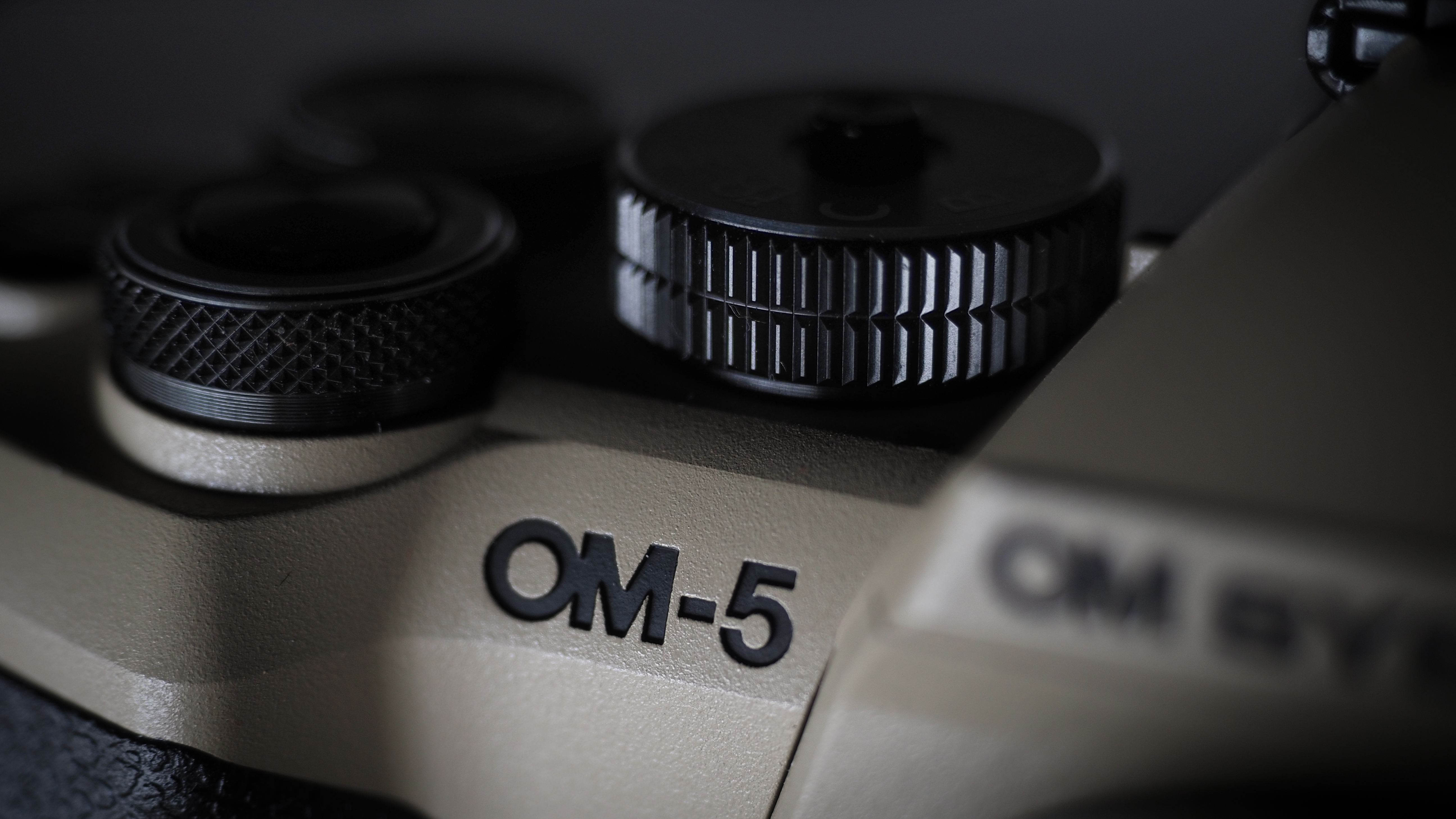 OM System OM-5 Mark II on a wooden surface with an Olympus M.Zuiko 12-45mm lens
