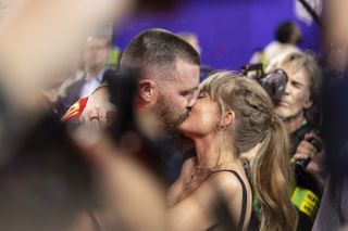 Travis Kelce #87 of the Kansas City Chiefs celebrates and kisses Singer Taylor Swift following Super Bowl 58
