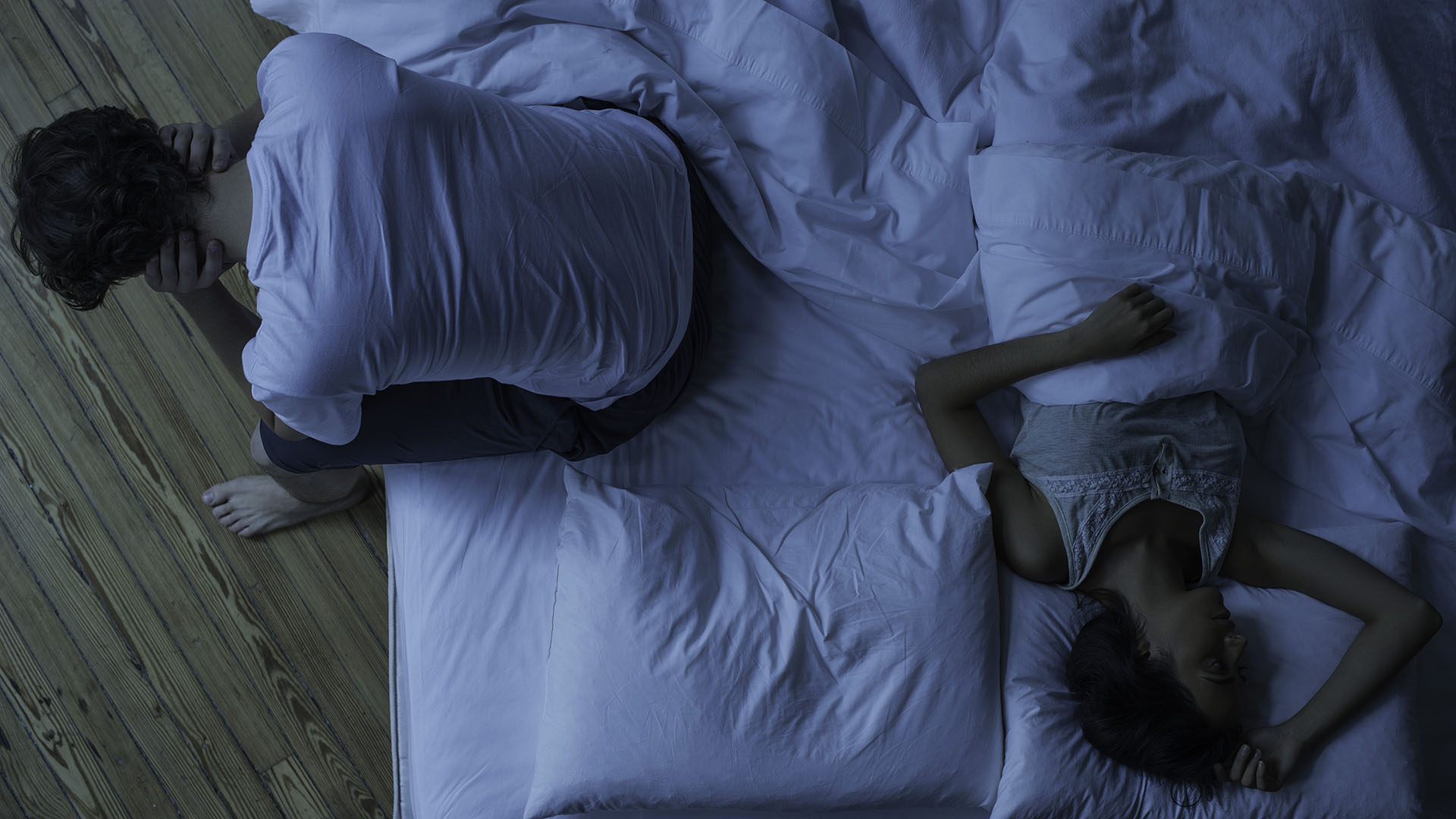 мужчина просыпается в постели, пока его партнер спит