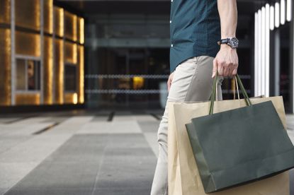 Close up of shopping bags held by a man.