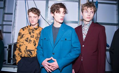 Three models stood next to each other - one in a yellow patterned, one in a blue jacket and one in a red jacket