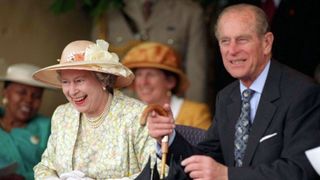 Queen With Prince Philip Laughing As She Watches Display Of Young Zulus Dancing During Her Visit To South Africa. They Praised Her For Bringing Rain That They Badly Needed