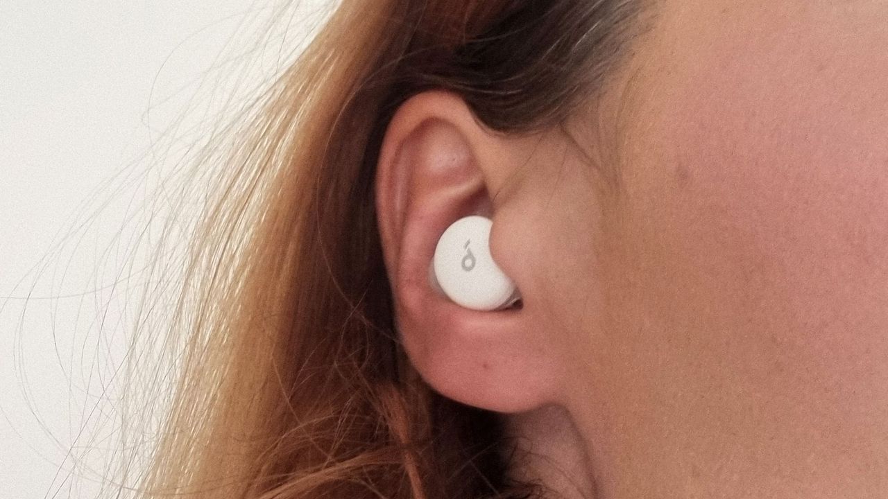 A close-up picture of our reviewer testing the Soundcore Sleep A30 earbuds