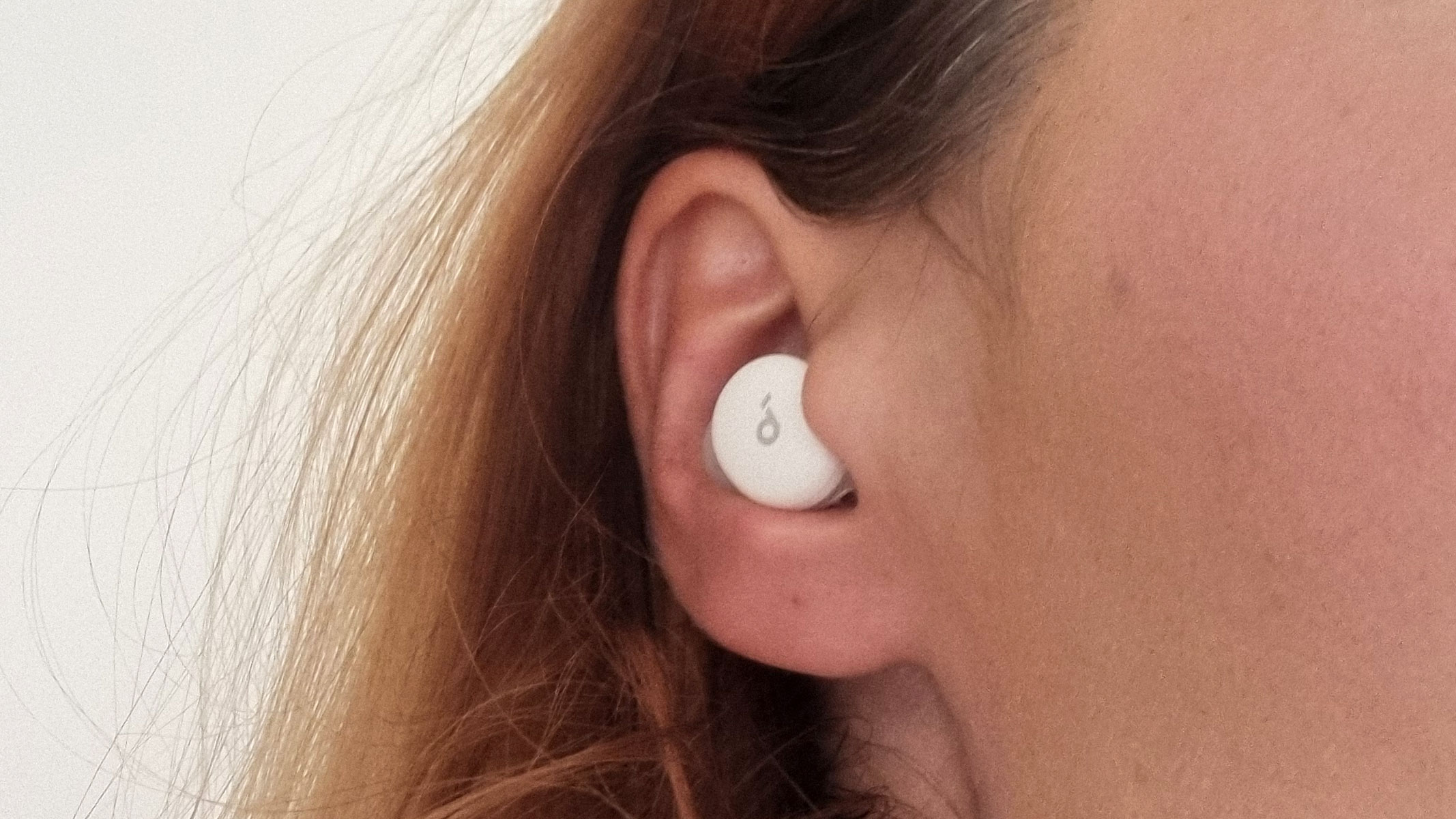 A close-up picture of our reviewer testing the Soundcore Sleep A30 earbuds