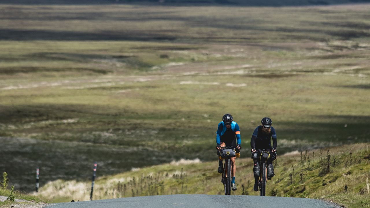 Two cyclist ride up a steep road climb
