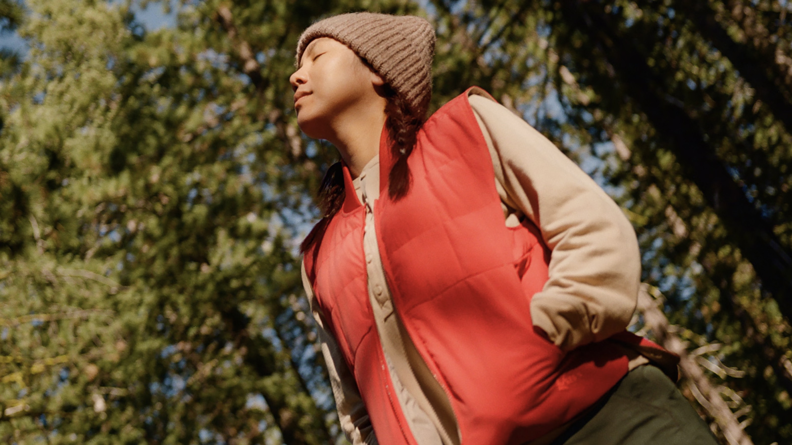 Person standing in a forest in outdoor apparel