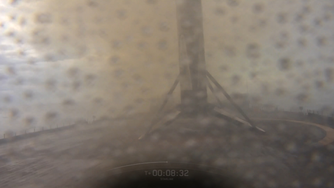 A sooty SpaceX rocket stands on an ocean drone ship platform after landing