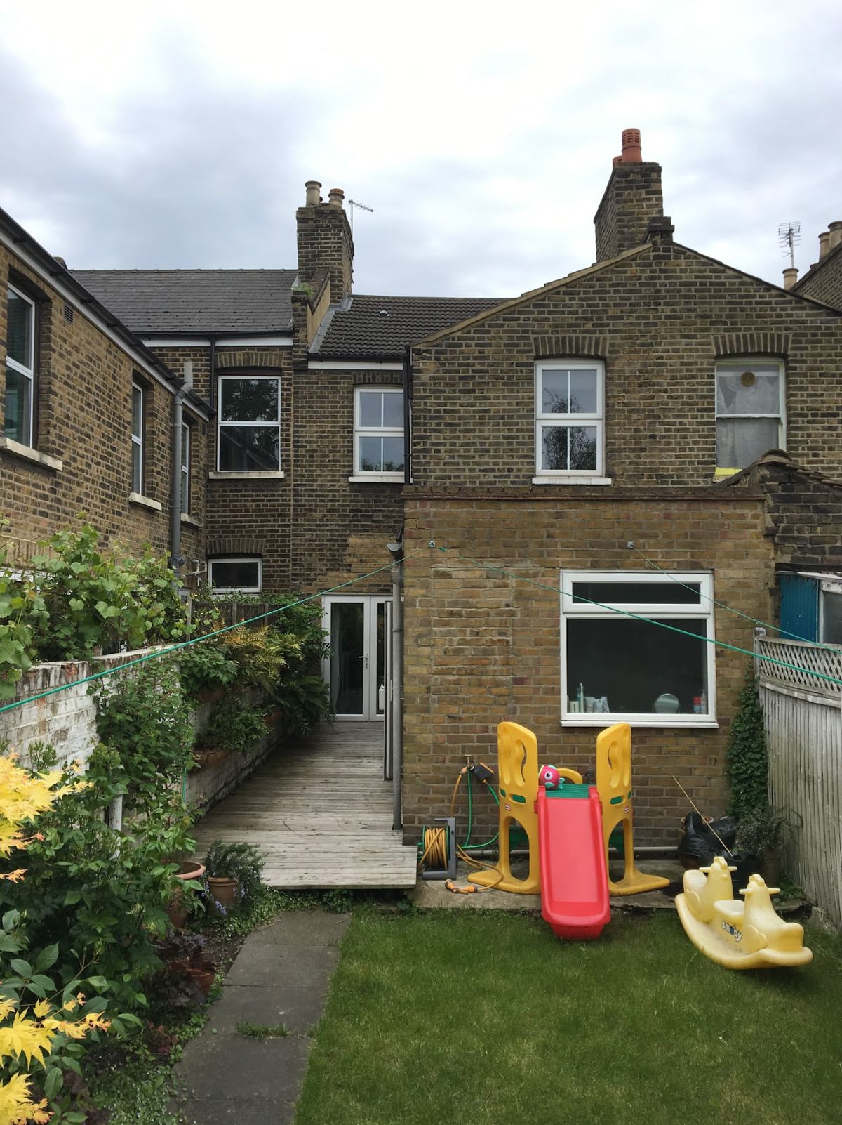 A before shot of a Victorian terrace house garden with a childs slide