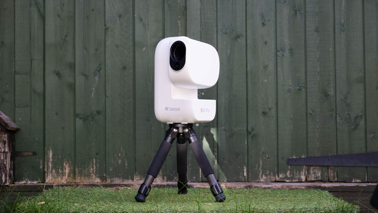 ZWO Seestar S50 Pro on a tripod against a green shed