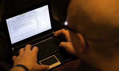 A participant looks at lines of code on a laptop at a computer hacker conference on December 27, 2011 in Berlin.