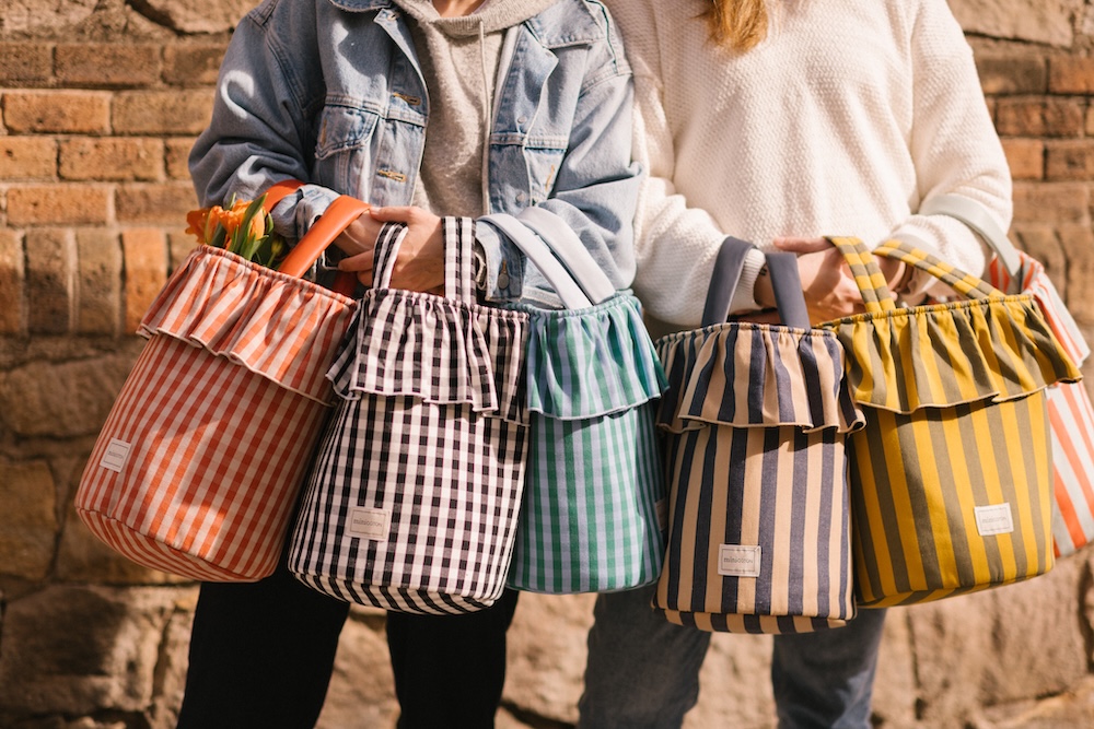 two models carrying armfuls of MiniCoton bags