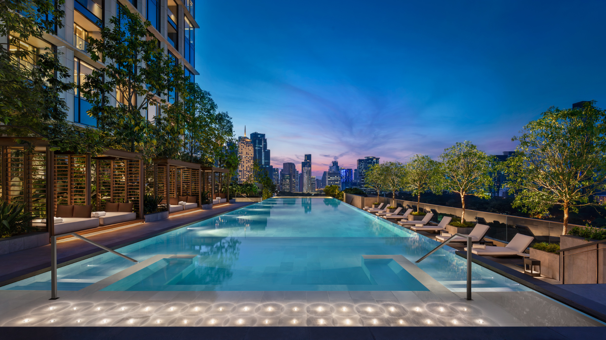 An outdoor pool surrounded by lounges and cabanas at the Ritz-Carlton, Bangkok
