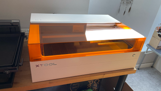 xTool S1 review; the top of a laser machine, an orange lid