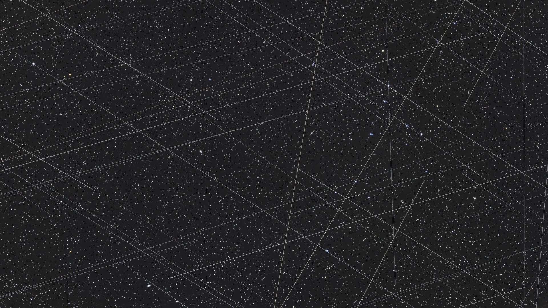An image of many criss-crossing beams of light in the starry night sky