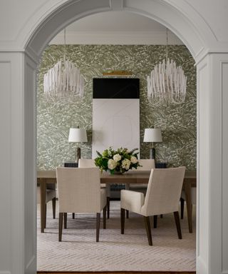 Dining table and chairs with two chandeliers above