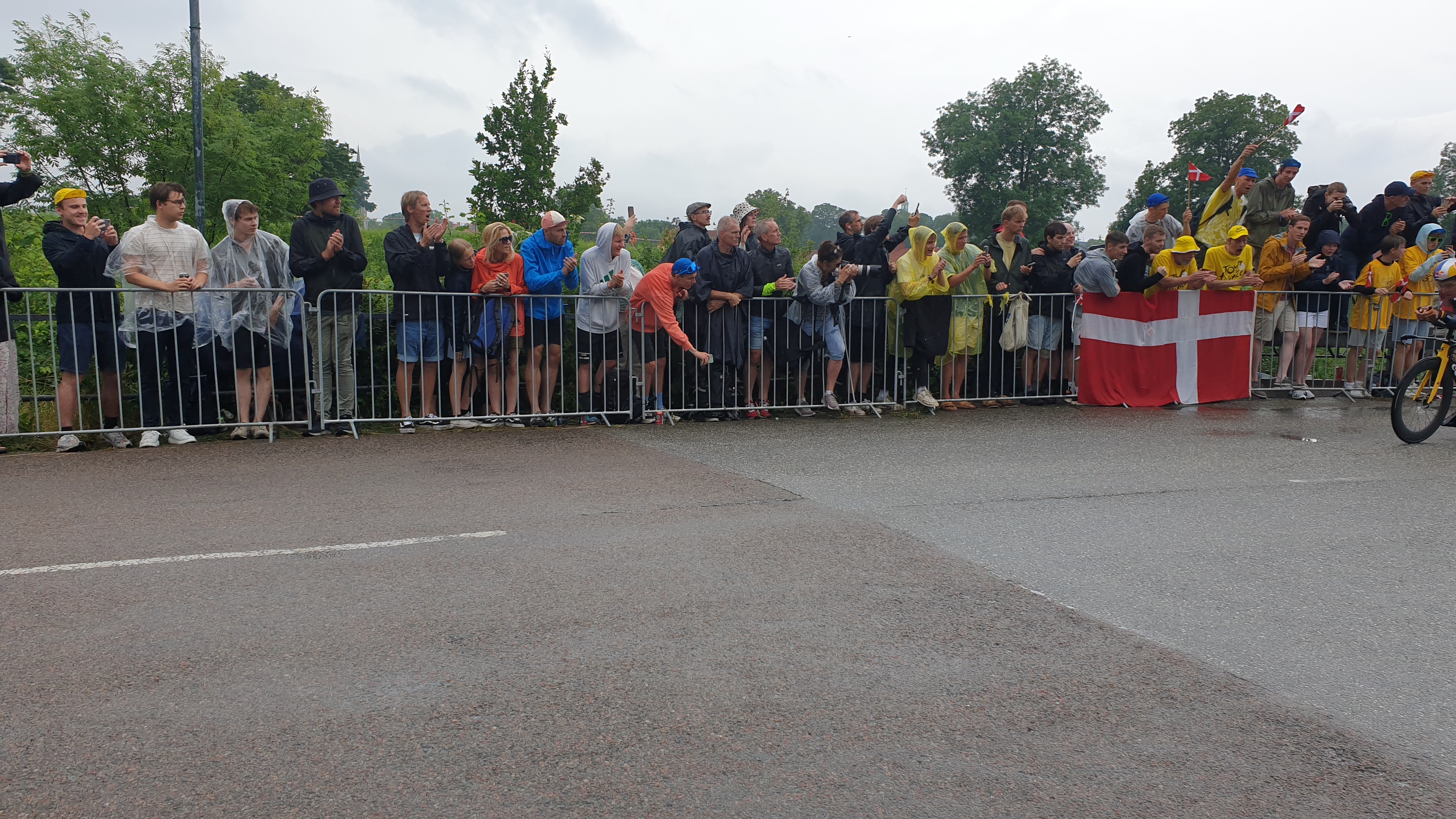A photo of fans along the roadside of stage 1 of the Tour de France in Copenhagen, with a cyclist just entering the frame on the right hand side