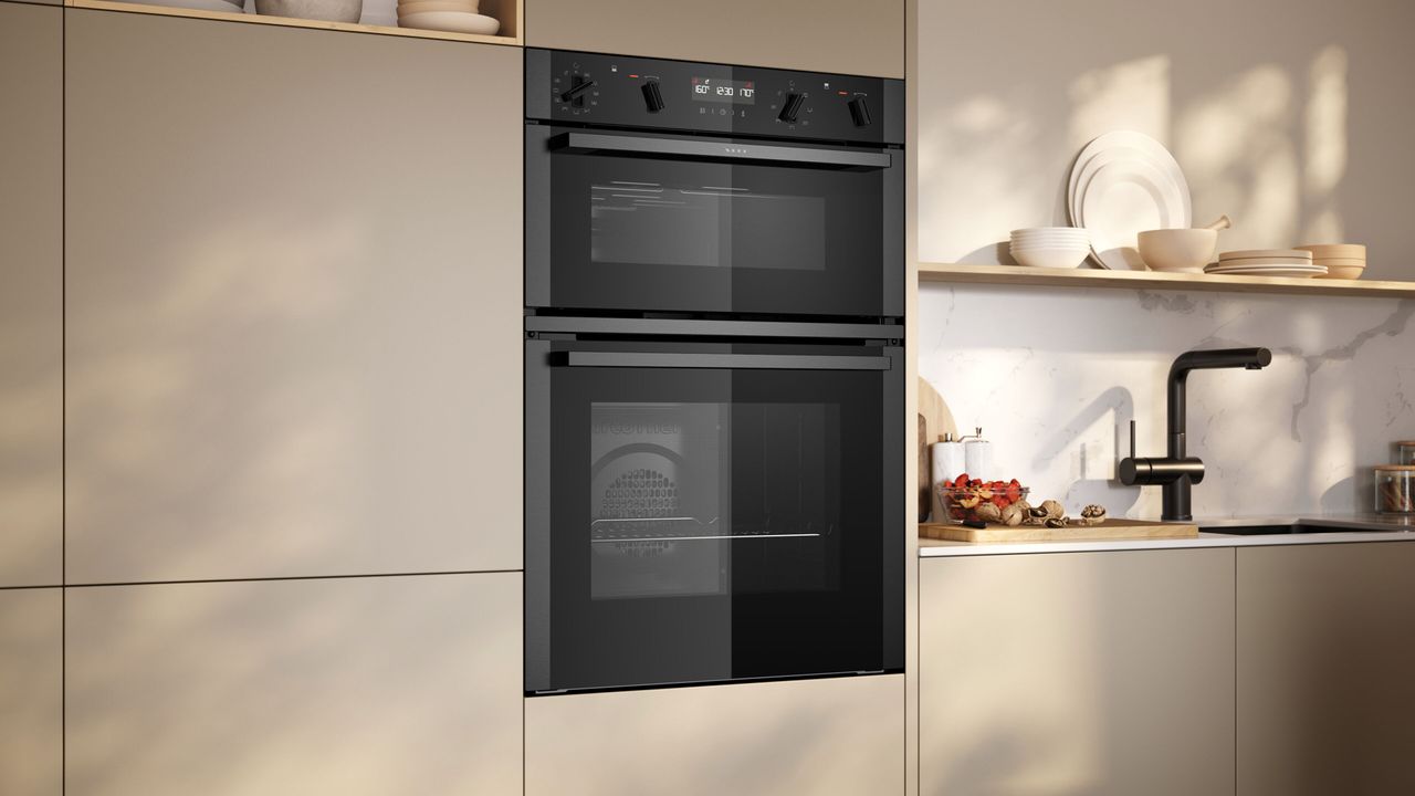 A kitchen in off white tone, with a double oven