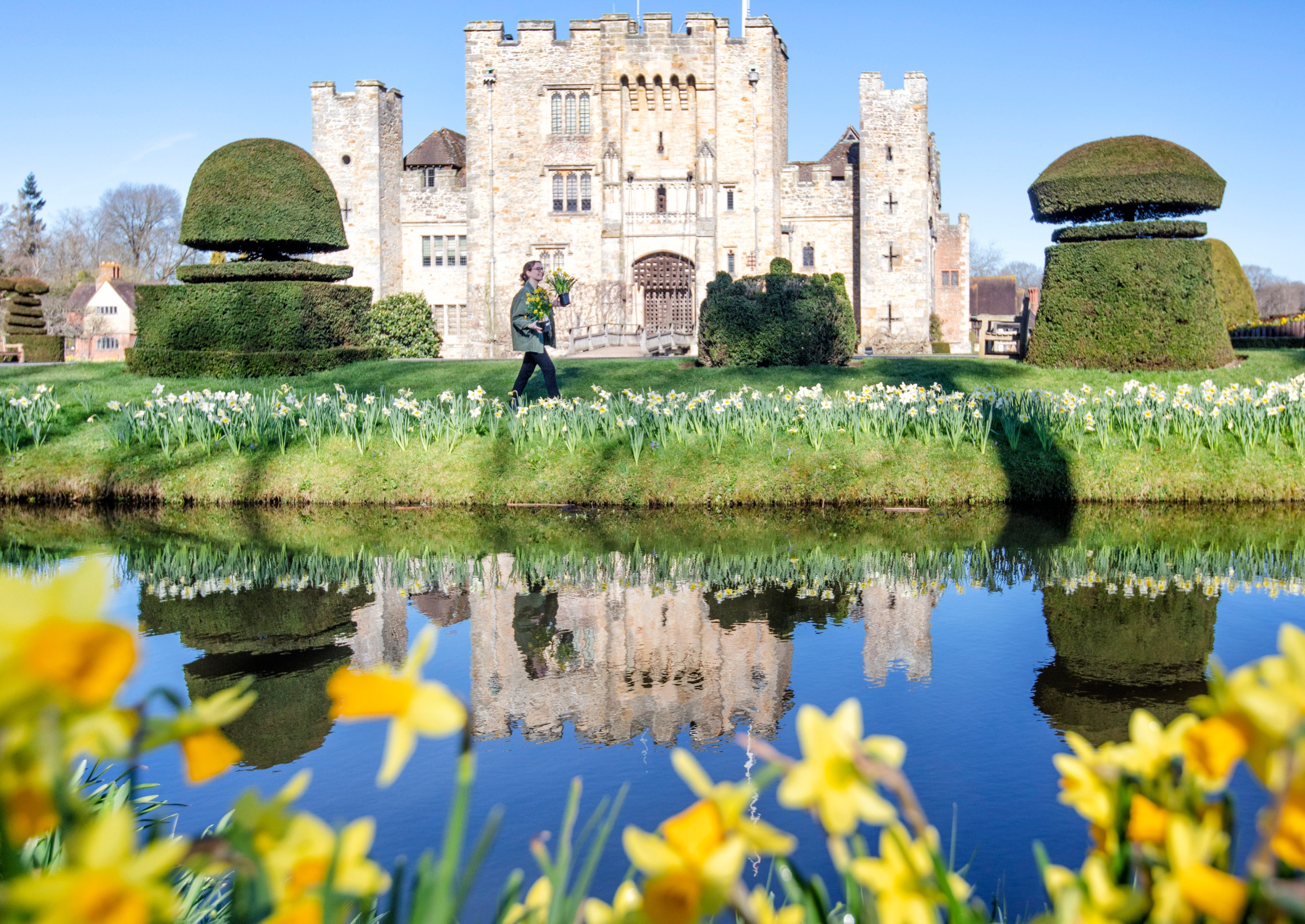 A woman walks through a garden at Hever Castle in Kent