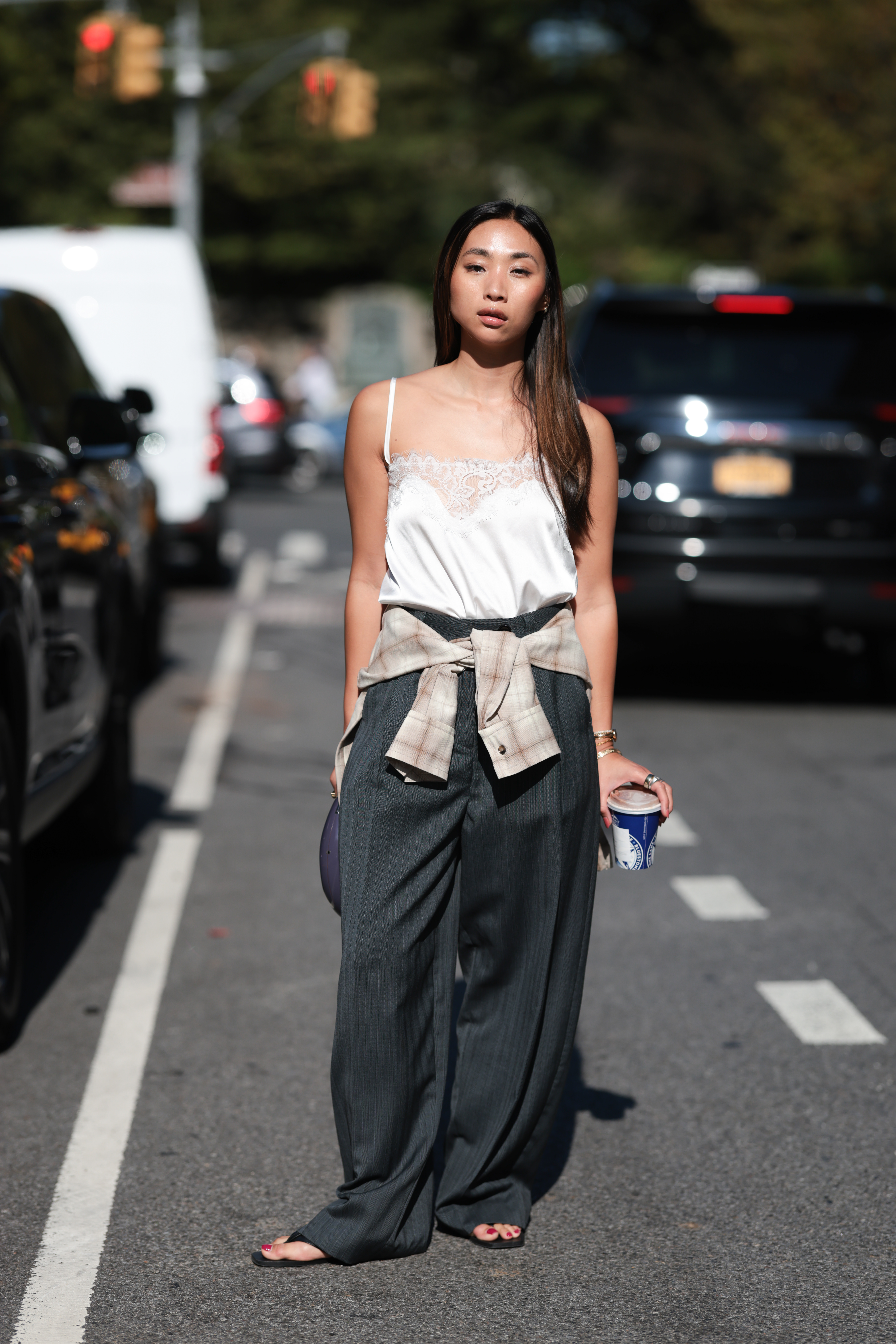 A woman wears a plaid shirt tied around her waist.