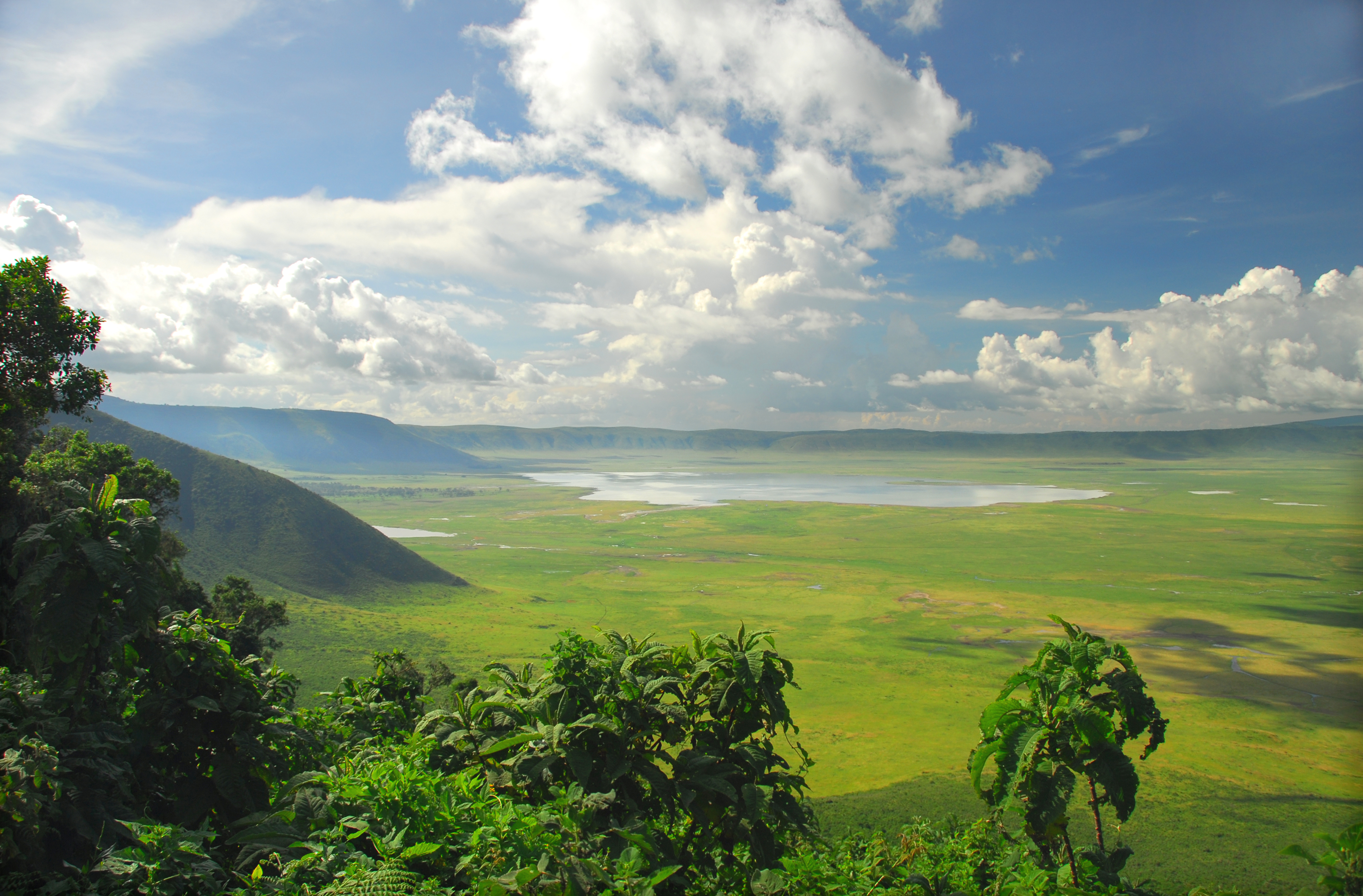 The Ngorongoro Crater in Tanzania seen from the top of a ridge with bright sunlight.
