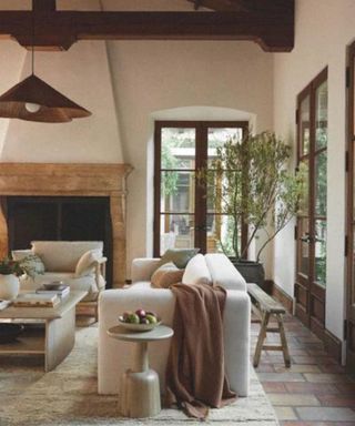 Cozy living room with neutral color scheme, large stone fire place and rattan lighting