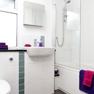white bathroom and shower with tiled basin