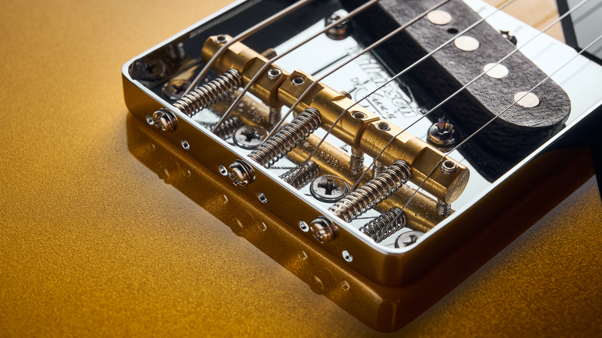 Close up of the compensated brass saddles on the Wilkinson bridge of the Baum Guitars Verve