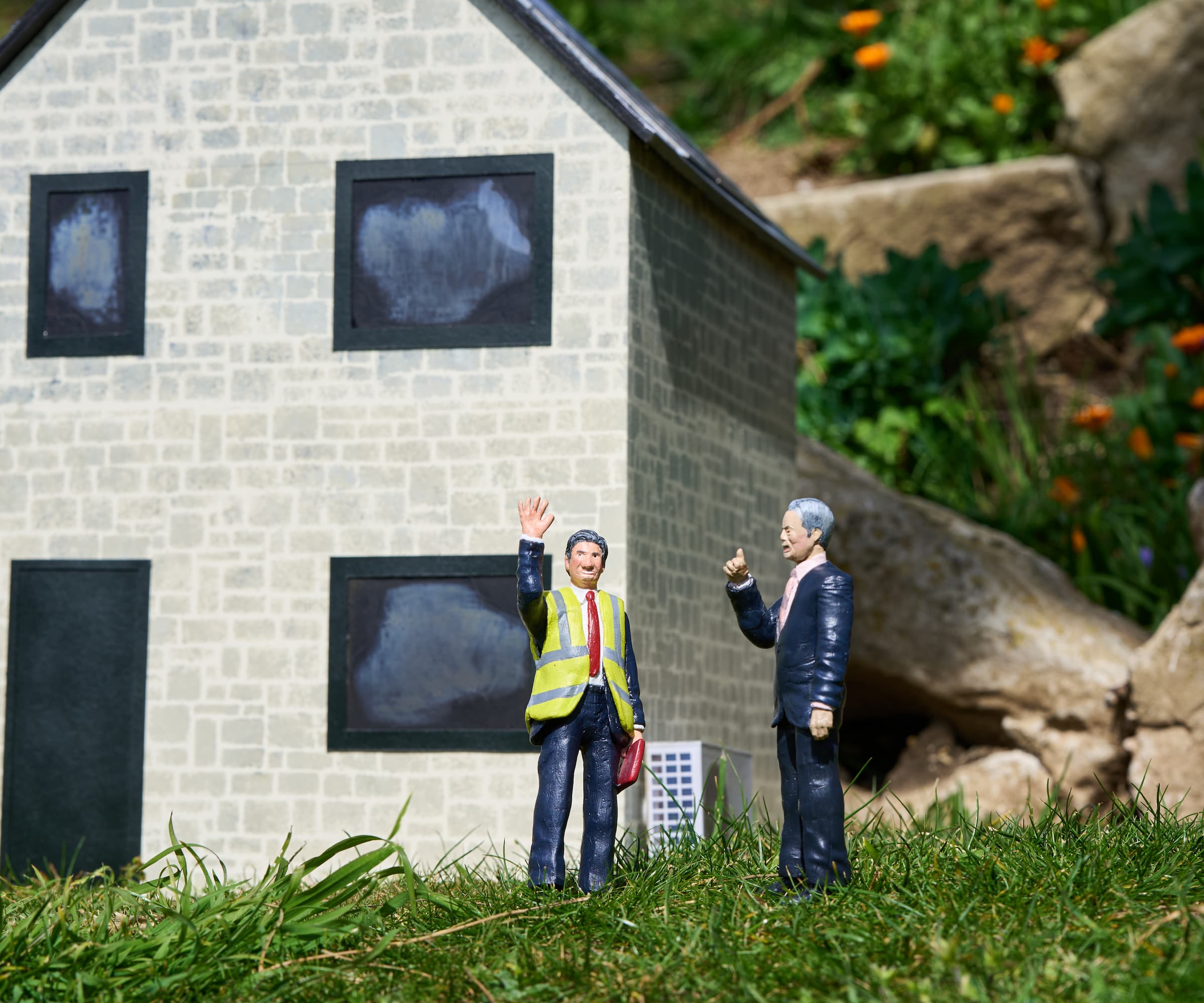 A miniature figurine of Ed Miliband and Nigel Farage arguing next to an eco house