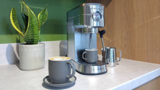 Casabrews 5418PRO espresso machine on kitchen counter with plant and cup of coffee