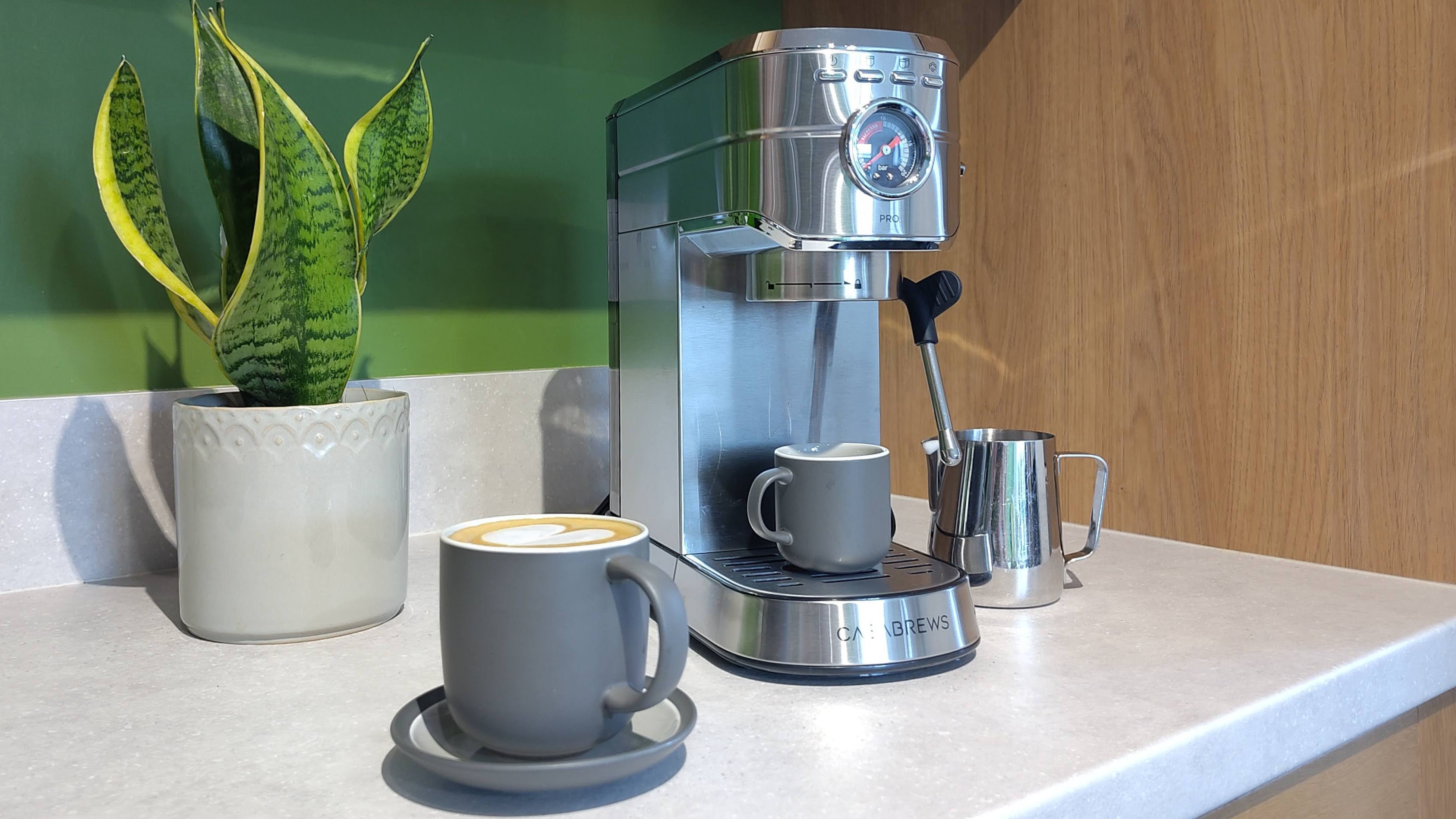 Casabrews 5418 Pro espresso machine on kitchen counter with plant and cup of coffee
