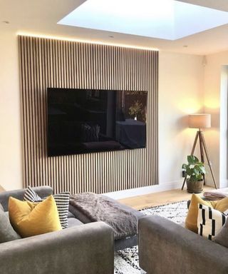 TV with an illuminated panel behind it as part of a modern contemporary living room scheme