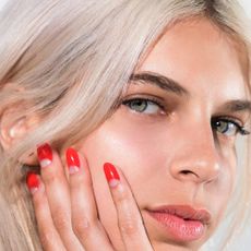 A model with red press on nails from Chillhouse against her face.