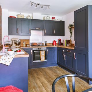 Blue u-shaped kitchen with dining area