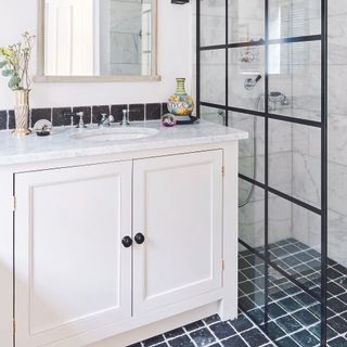 Bathroom with white cabinet next to crittall shower door