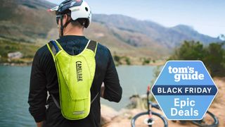 Man wearing CamelBak pack in front of lake